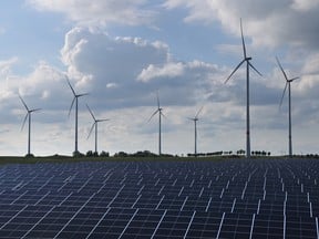 Wind turbines spin behind a solar energy park near Prenzlau, Germany.